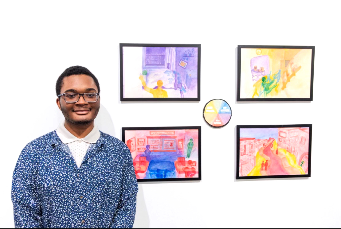 Ryan Williams proudly stands in front of artwork called "Conflicting Perceptions." (Photo CUE Art Foundation)