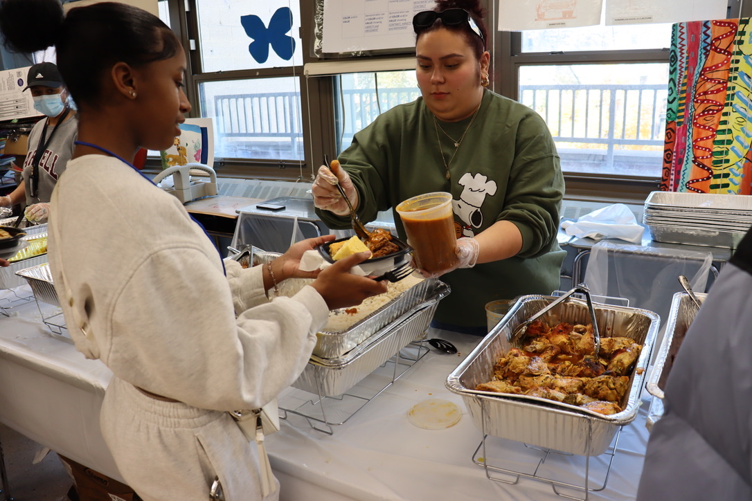 Chanel Crispin is served the Pacegiving meal by Ms. B. Miranda. Parent volunteers also help serve the meal to students.