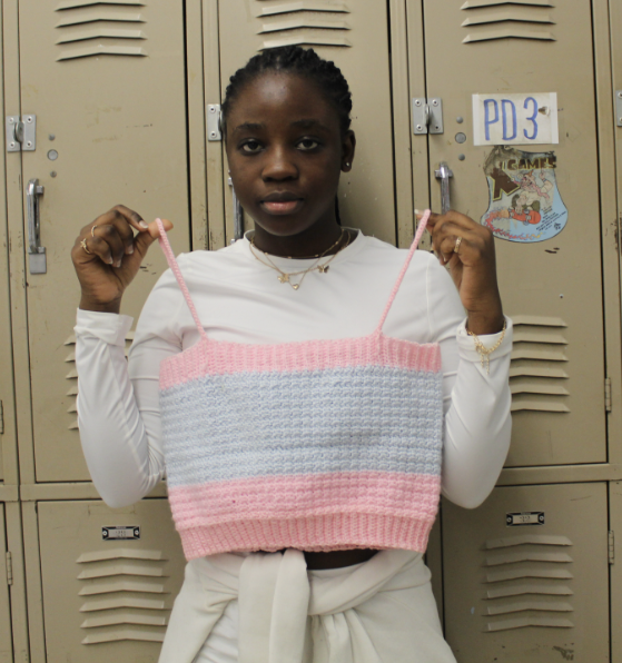 Aliyat shows off her crocheting skills with one of her many creations, a blue and pink vest.