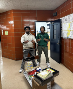Andre Albert and Stephon Peppers bringing materials to the English wing of the school.