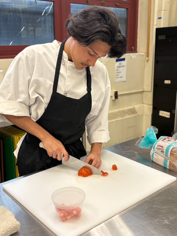 Mariusz Surowka dices a tomato for his culinary class at Coop Tech.

(Photo Contributed by Mariusz Surowka)
