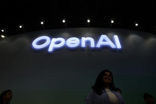 A woman poses for pictures in front of the OpenAI logo at Bharat Mandapam, one of the venues for AI Impact Summit, in New Delhi, India, February 17, 2026.