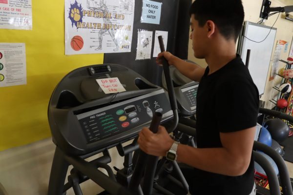 Freshman Afruz Tolibov has a hard time using the broken elliptical machine.