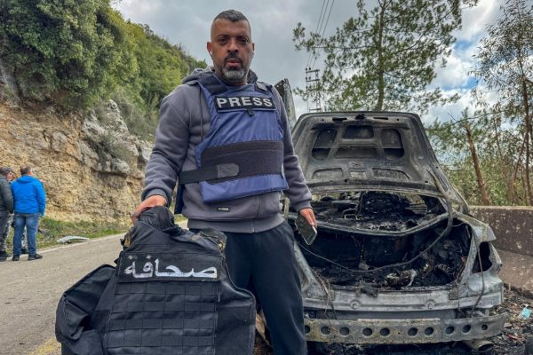 Al Mayadeen journalist Jamal Al-Gharabi holds a press vest next to a car destroyed by a targeted Israeli strike that killed Lebanese journalists Al Mayadeen reporter Fatima Ftouni and cameraman Mohammed Ftouni, and Al Manar reporter Ali Shaib, amid escalating hostilities between Israel and Hezbollah, as the U.S.-Israeli conflict with Iran continues, in Jezzine, in southern Lebanon, March 28, 2026. REUTERS/Ali Hankir
