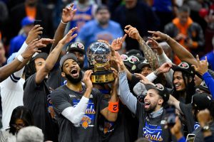 May 25, 2026; Cleveland, Ohio, USA; New York Knicks center Karl-Anthony Towns (32) lifts the 2026 Eastern Conference trophy with teammates after defeating the Cleveland Cavaliers in game four of the eastern conference finals for the 2026 NBA playoffs at Rocket Arena.